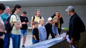 A group of visitors, including adults and children, on a guided tour of the Sachsenhausen Concentration Camp Memorial