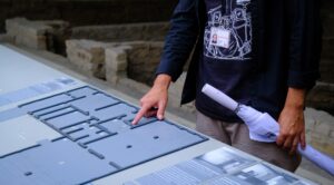 Guide Richars points to a map at Sachsenhausen, explaining the historic site.